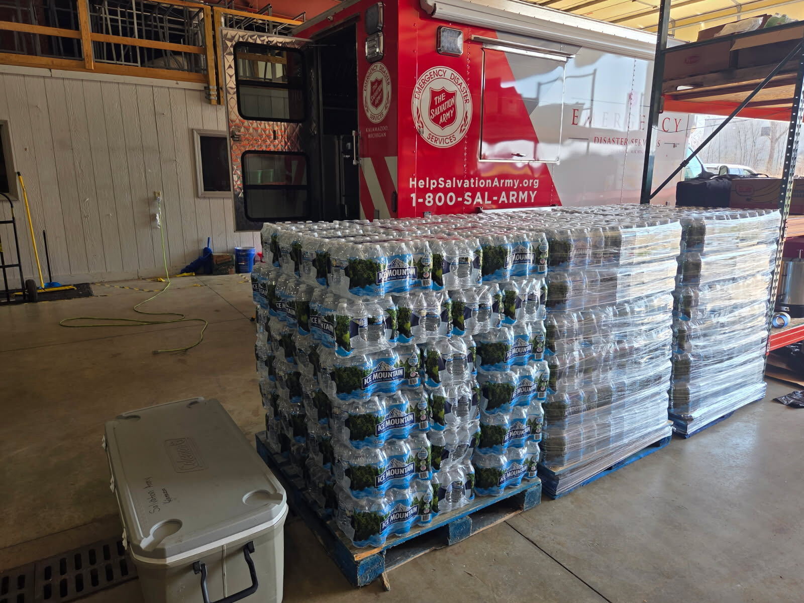 Pallets of Ice Mountain bottled water staged beside a Salvation Army Emergency Disaster Services truck